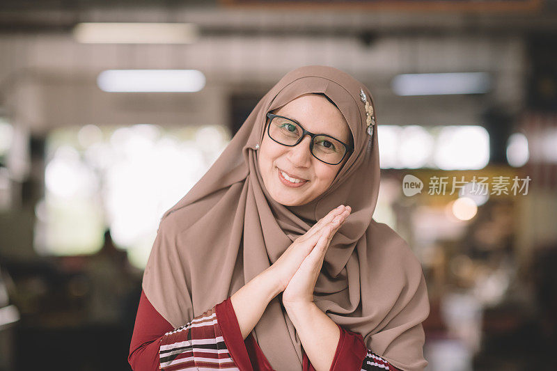 一名亚洲穆斯林女性早上在户外的菜市场以积极的情绪爆头