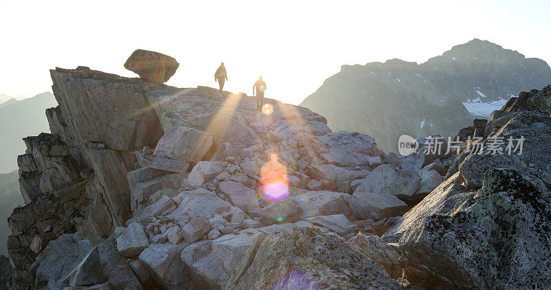 两名登山运动员在日出时横越山脊