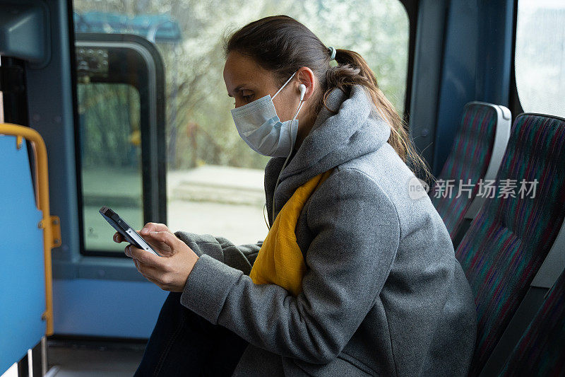冠状病毒保护。妇女戴着防护口罩以避免感染疾病，在公交车上上网。