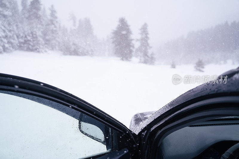 司机的POV驾驶在积雪覆盖的道路上，被困在了第一个下雪的道路上。冬季暴风雪天气耽搁了。山里有暴风雪。