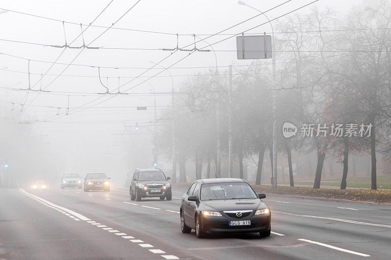 清晨大雾弥漫在城市街道上。道路交通。