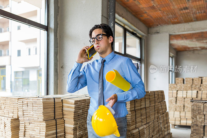 土木工程在建筑工地工作时使用智能手机。