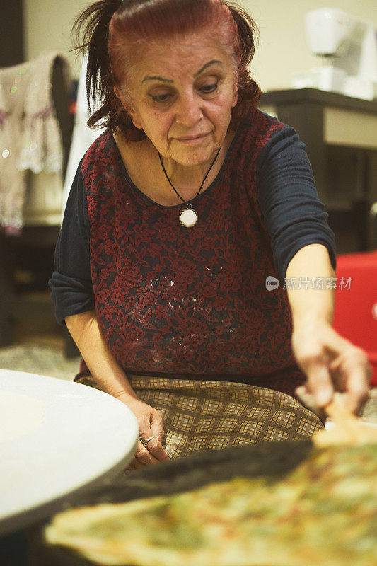 一个女人正在客厅里用电子设备做馅饼