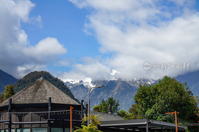 远处的山上覆盖着积雪。克朗街景在弗朗茨约瑟夫冰川村，西海岸地区，新西兰