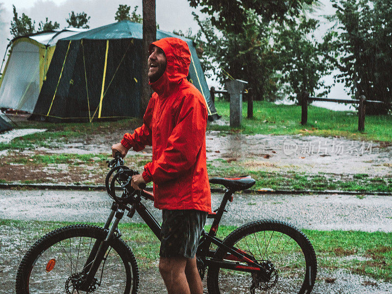 一名山地摩托车手冒着暴雨回来露营