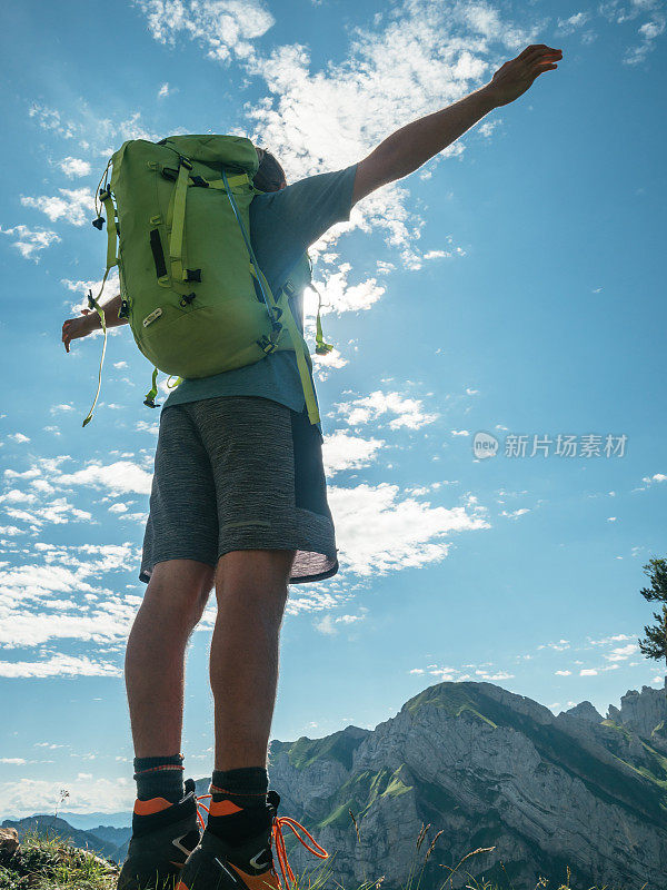 男人在山顶张开双臂