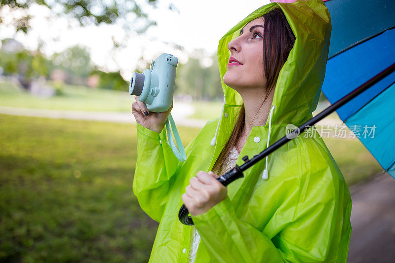 漂亮凉爽的女人带着五颜六色的雨伞在秋天的一天