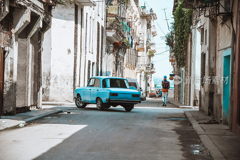 古巴哈瓦那，一辆蓝色汽车正在街角行驶