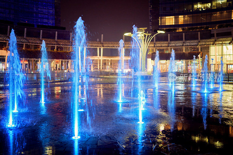 被现代摩天大楼包围的盖奥伦蒂广场上的发光喷水池。门加里波第区。意大利米兰——2020年12月17日。