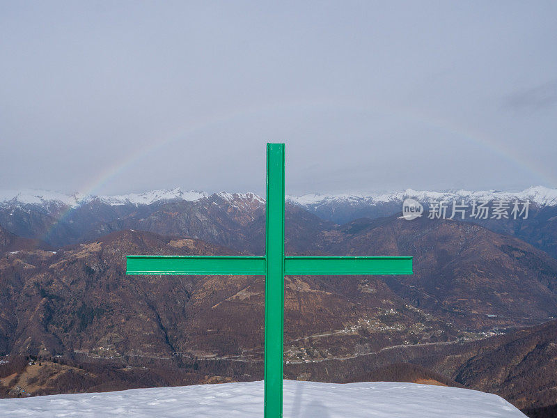 彩虹在瑞士阿尔卑斯山的提契诺，宗教十字架在山顶