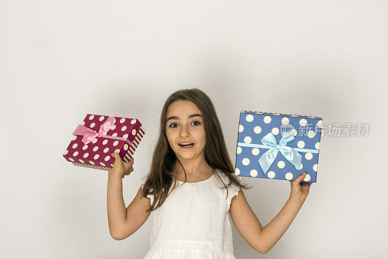 快乐的小女孩手里拿着礼物盒在白色的背景