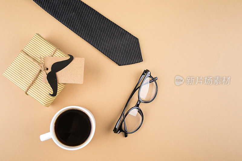 礼品盒，纸胡子，眼镜，领带，中性背景的咖啡。父亲节快乐。俯视图，复制空间