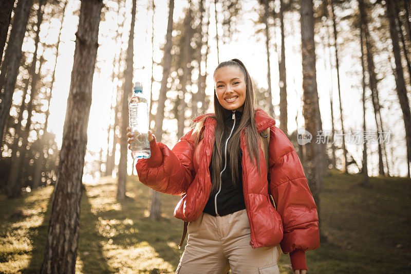 成功的女人徒步登山在日出的山顶-年轻的女人背包上升到山顶。发现旅游目的地