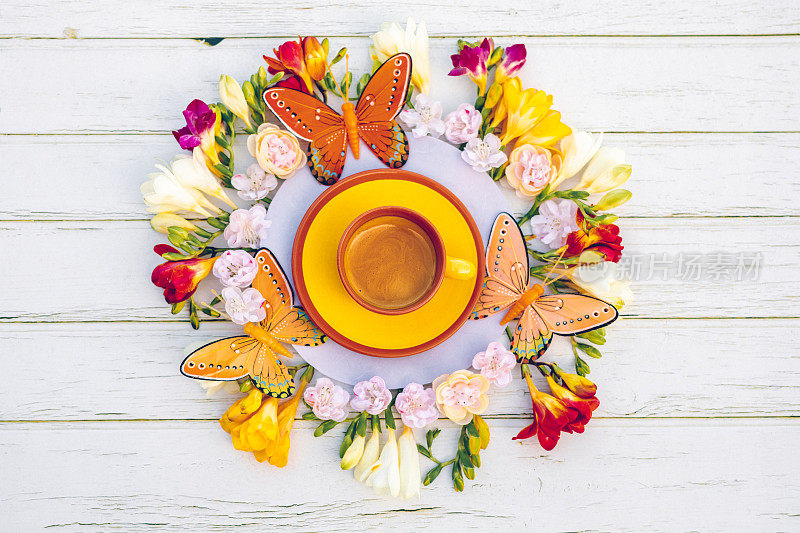 美丽的平躺在波西米亚风格与小苍兰，樱花，蝴蝶和一个黄色的杯与奶油咖啡曼陀罗