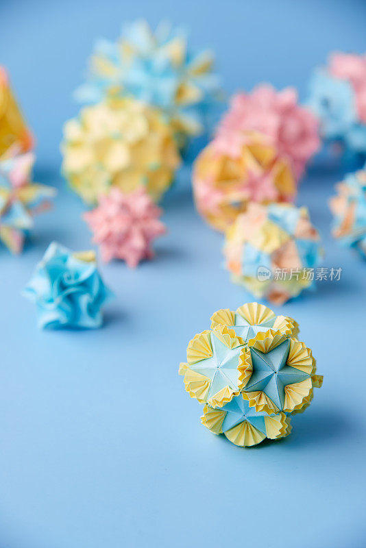 Set的multicolorÂ手工制作modularÂ折纸球或Kusudama孤立在蓝色背景。视觉艺术，几何学，折纸艺术，纸工艺品。特写，选择性聚焦，复制空间。