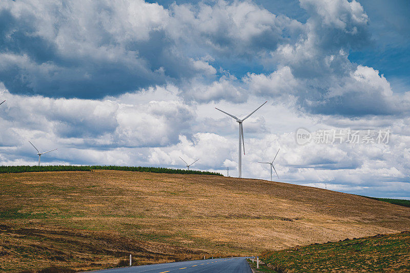 在风力发电机下的草原山间公路