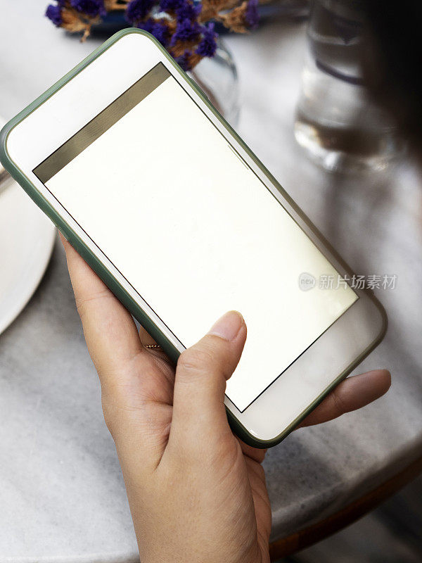 使用智能手机的女性，在白屏上使用智能手机的女性双手特写