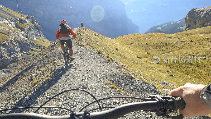 山地自行车手沿着瑞士阿尔卑斯山的小道骑行
