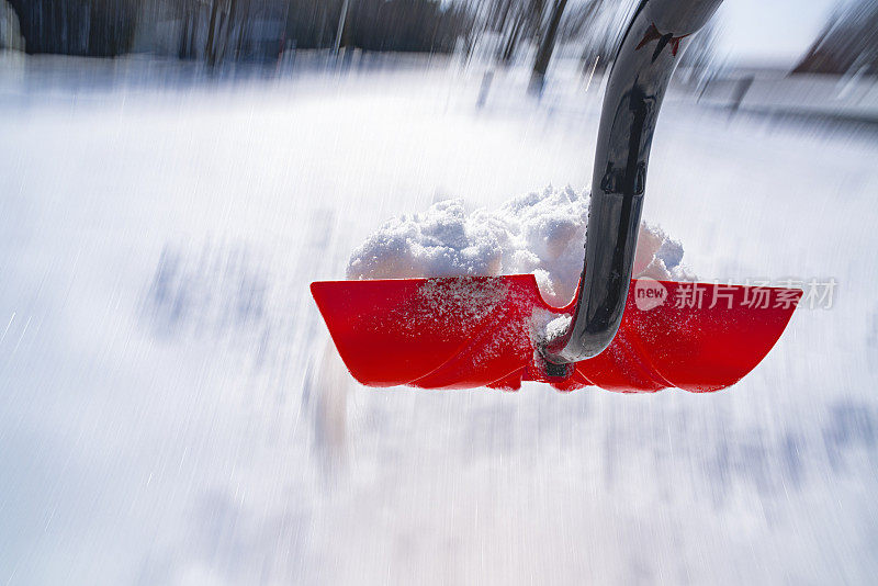 一个低视角的雪铲在半空中投掷的雪，运动。