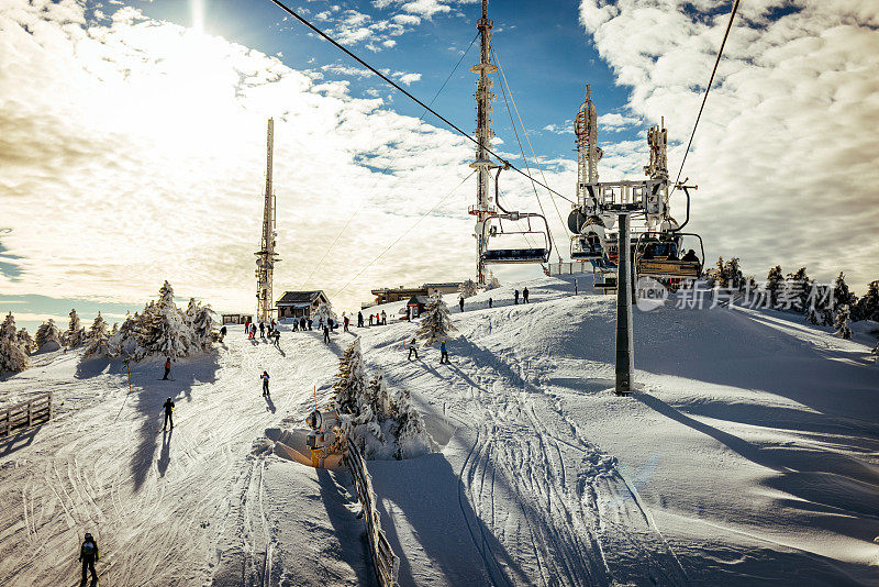 在一个阳光明媚的寒冷日子里滑雪缆车和小道。