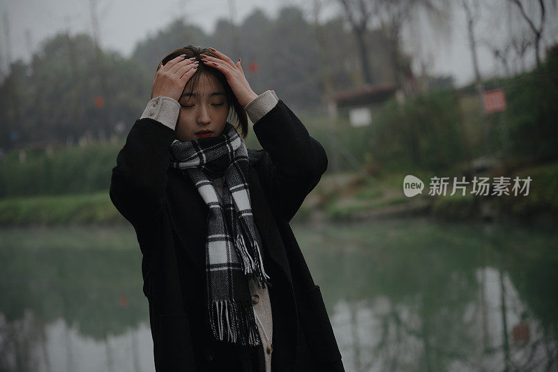 亚洲女孩走在河边的雨天