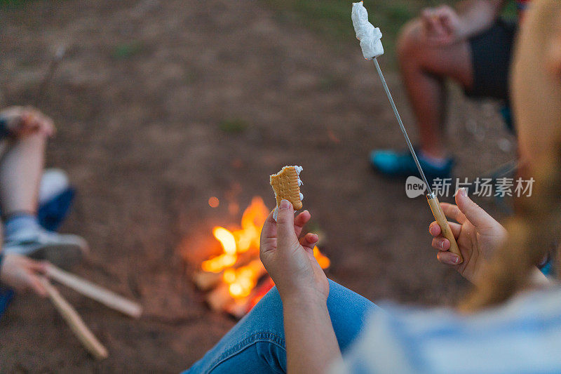 一个年轻人和朋友在户外露营时做棉花糖三明治的特写