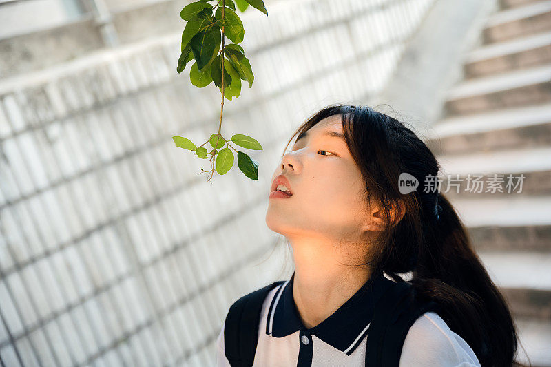 亚洲女孩在阳光下快乐地走下楼梯