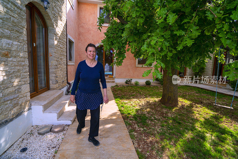 克罗地亚伊斯特里亚，一个成熟的女人走在后院。