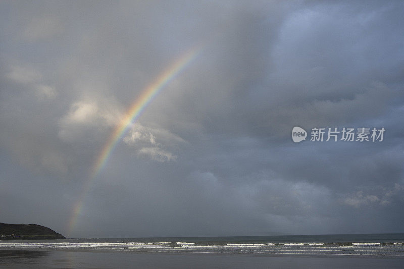 彩虹在海滩和海上升起