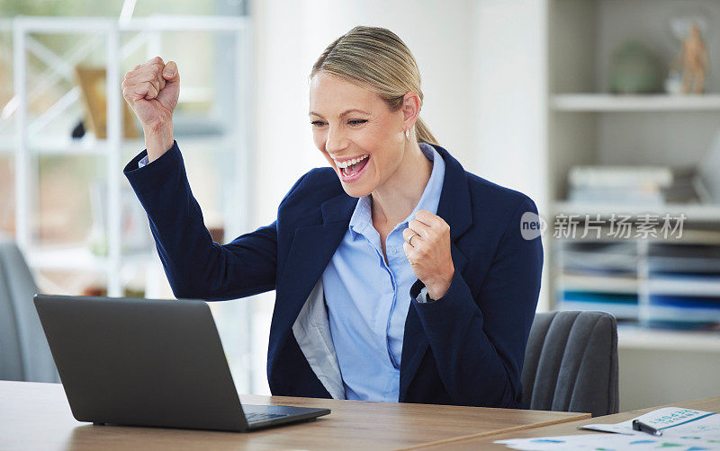 快乐，兴奋和成功的商业女性庆祝与笔记本电脑在线，赢得和欢呼的成就，同时在办公室工作。企业和专业人员收到好消息
