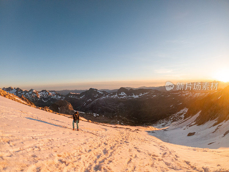 女登山者在雪道上攀登山峰