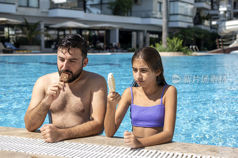 快乐的帅哥和他美丽的妹妹在泳池边吃冰淇淋