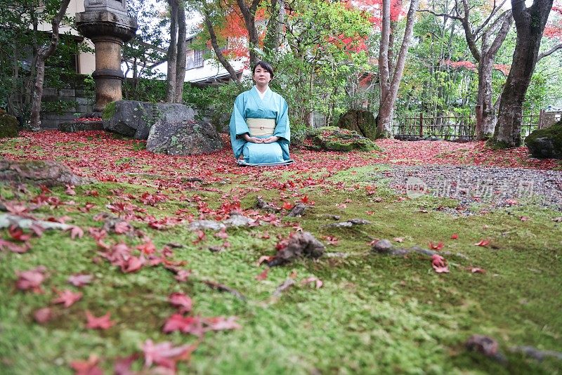 日本女子在传统的日本旅社花园冥想