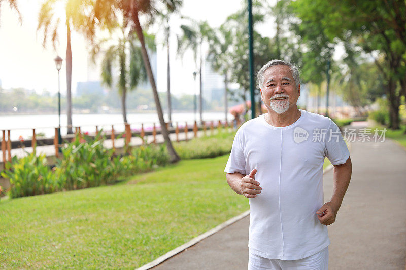 夏季退休后，快乐微笑的亚洲老人在公园户外运动，慢跑或散步，放松身心，保持健康。养生老人户外生活理念。