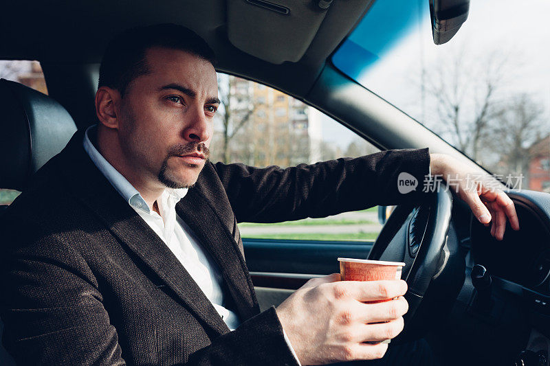 男人边开车边喝咖啡
