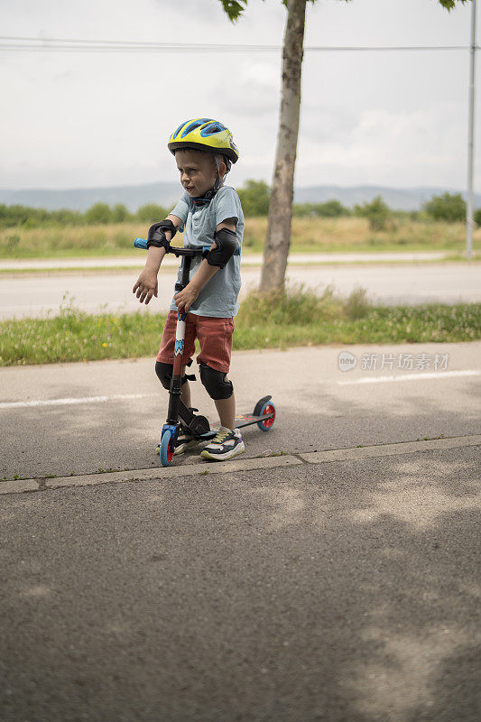 小男孩骑摩托车。孩子们玩滑板