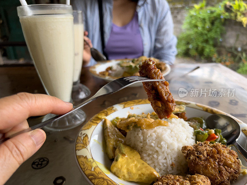 POV，亚洲母亲和女儿吃素食纳西坎普尔，印度尼西亚