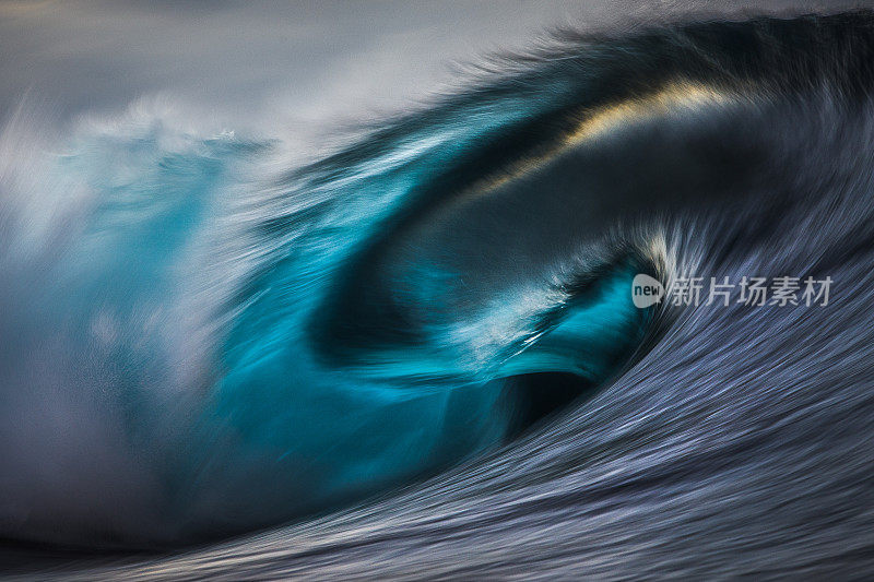 强大的蓝色波浪在浅海礁石上的艺术照片