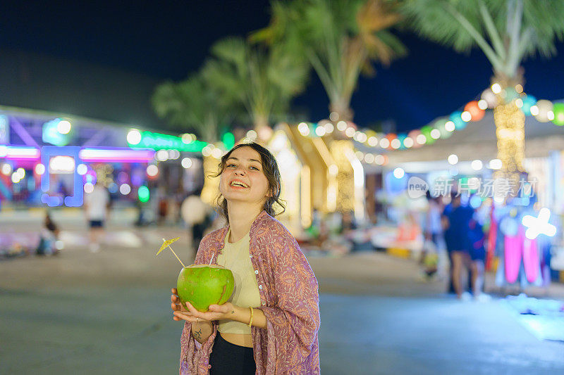 一名女子在曼谷的夜市上吃着椰子冰淇淋