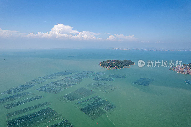 鸟瞰海中的小岛和海上漂浮的水产养殖场