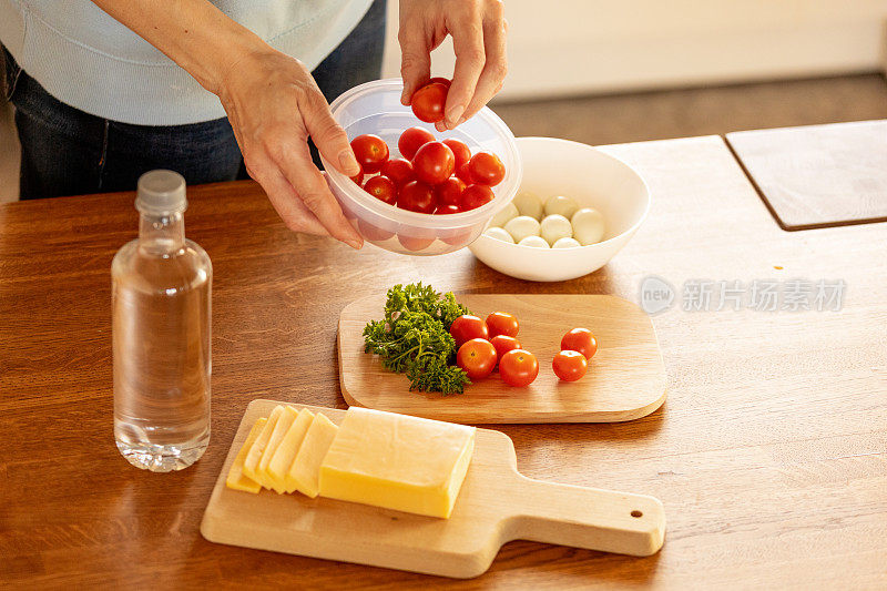 妇女用塑料容器收集食物