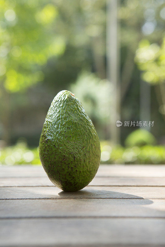 公园里的木桌上放牛油果。水果和蔬菜概念。