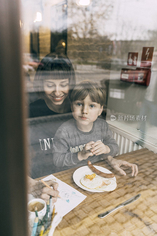 母亲和儿子在咖啡馆吃饭