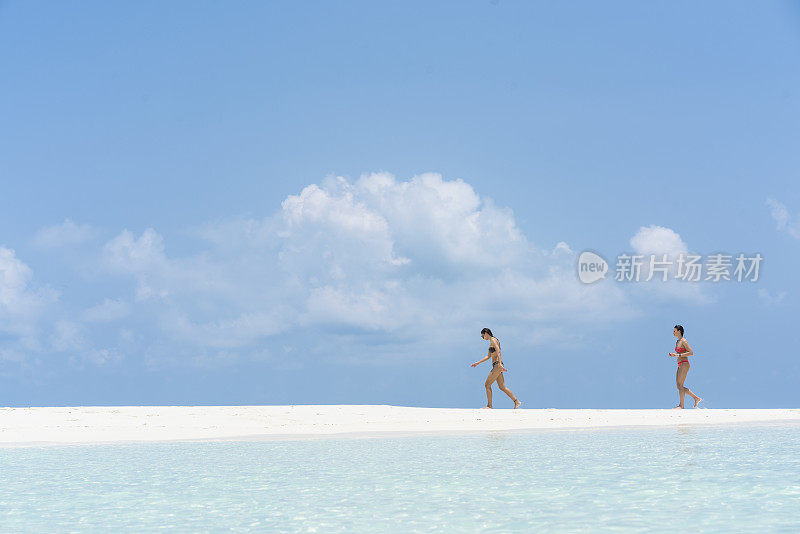 二、年轻美丽的女子在马尔代夫小岛屿海滩的水边奔跑