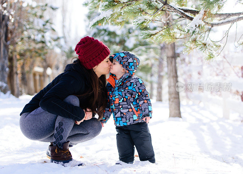 和妈妈一起在雪地里快乐地蹒跚学步