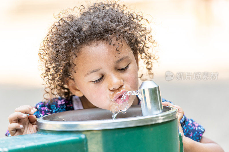 小女孩在校园里喝水