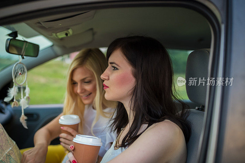 年轻女子正在开车，一边看地图。