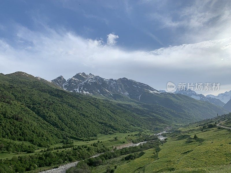 高加索山脉上美丽的高山草甸。牧场，山坡上的草地和白雪皑皑的山脉。