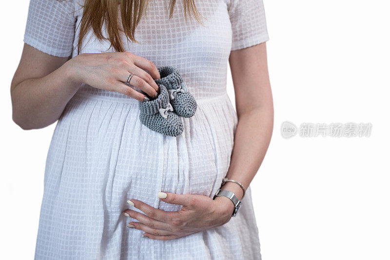 孕妇的肚子和新生儿的靴子