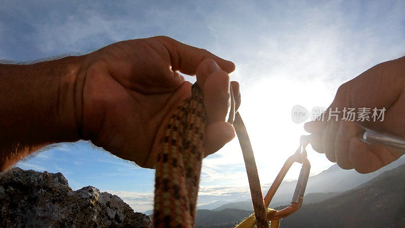 登山者在岩顶放置装备，以确保绳索安全